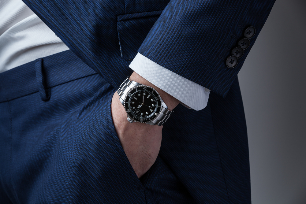 Man's hand in pocket with wrist watch in an expensive tailored suit