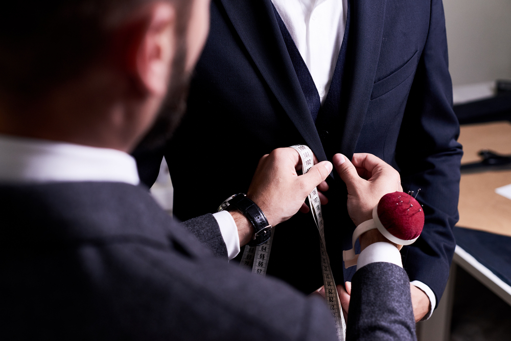 Man choosing the best suit tailors.